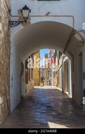 Narrow alley with arch, balcony decorated with red at the back, Can Mercadal, city library, Biblioteca Central Insular, Placa de la Conquesta, Mahon, Mao, Menorca, Spain, Europe Stock Photo