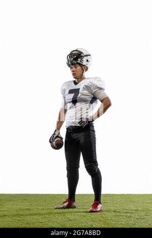 Portrait of young American football player, athlete in sports equipment standing isolated on white studio background. Concept of professional sport Stock Photo