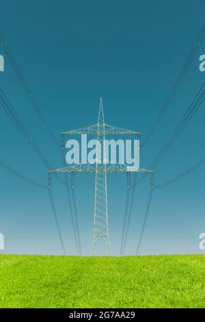 Electricity pylon on a green meadow Stock Photo