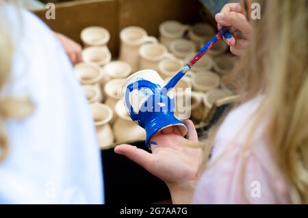 little children colouring an ceramics craft Stock Photo