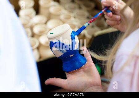 little children colouring an ceramics craft Stock Photo