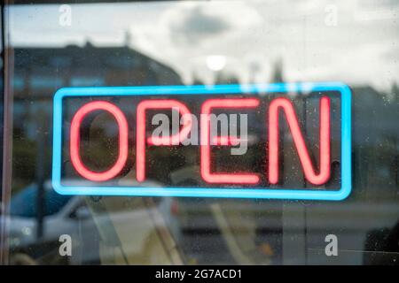 Neon sign of open with red letters and the border as blue. Stock Photo