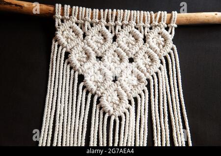Decorative handmade stylish cotton macrame decoration, hobby interior for hanging on black background. DIY boho home interior decor, eco friendly mode Stock Photo