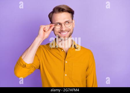 Portrait of cheerful person hand touch glasses toothy smile look empty space isolated on purple color background Stock Photo