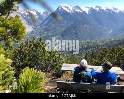 Two hikers look at the lookout bench into the Karwendel ,zaunlkopf, Karwendeltal, Gleirschtal, Hinterautal, nature, hike, Scharnitz, Tyrol, Austria Stock Photo