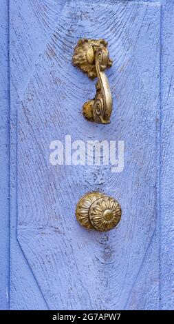 Door knocker and doorknob on door in Palalda near Amélie les Bains. Stock Photo