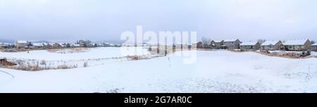 White snowy view of a town with large houses covered in snow Stock Photo