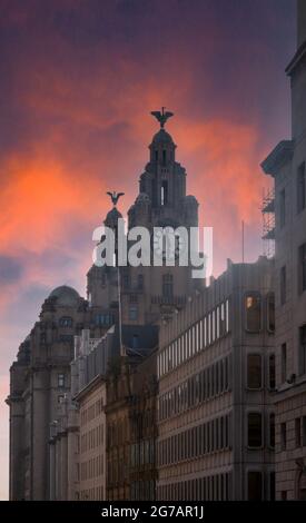 Towers of the Royal Liver Building with liver birds Bella and Bertie on top of towers against the dusk sky in Pier Head, Liverpool Stock Photo