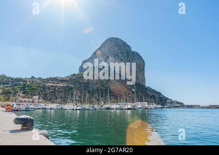 Calpe Spain - August 24 2016;Rock of Ifach, large rock landmark with marina below in coastal tourist town. Stock Photo