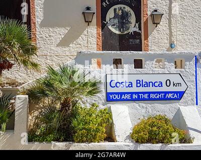 Calpe, Alicante, Spain - August 24 2016; Humorous sign advising distance of ) to Costa Blanca in coasta town Calpe, Alicante, Spain on exterior of bui Stock Photo