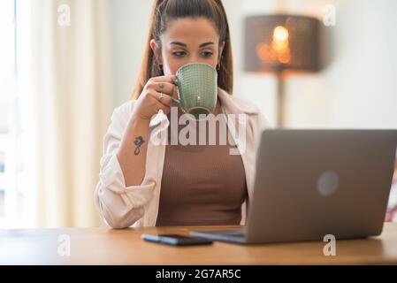 Portrait of caucasian young woman working and typing on laptop computer keyboard - office and smart working job concept for professional business or employee corporate company Stock Photo