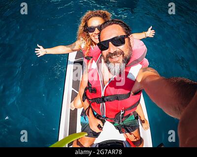 Top view selfie image of joyful young adult couple on a jet sky adventure lifestyle - happy couple people smile and have fun in summer holidays vacation together Stock Photo