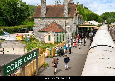 Corfe Castle, Dorset, England - June 2021: People on the platform of Corfe Castle railway station after arriving by steam train from Swanage. Stock Photo