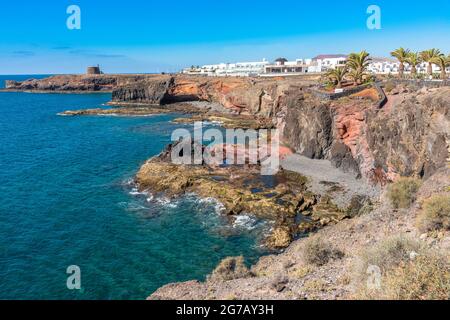 Cliffs and rocks jagged volcanic lava coastline promenade of famous Playa Blanca Papagayo. Atlantic ocean, Lanzarote south coast, Canary Islands, Spai