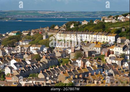 Residential houses, Fortuneswell, Underhill, Isle of Portland. Weymouth harbour beyond, Dorset, England, UK Stock Photo