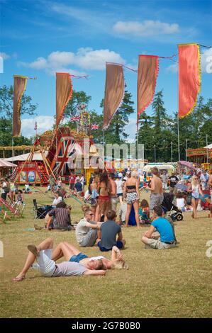 Festivalgoers enjoying the summer sunshine at a gestival in England. Womad festival, Chharlton Park, Malmesbury Wiltshire Stock Photo