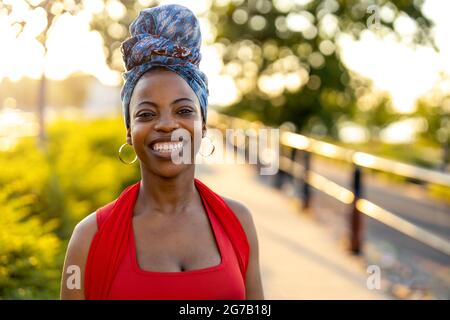 Young woman wearing a colorful head wrap outdoors Stock Photo