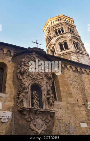 Right side of the ancient Church of San Donato (12th c.) with the Romanesque bell tower and a Baroque votive shrine (18th c.), Genoa, Liguria, Italy Stock Photo