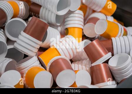 Many stacks of empty orange and brown plastic cups at warehouse - close up Stock Photo