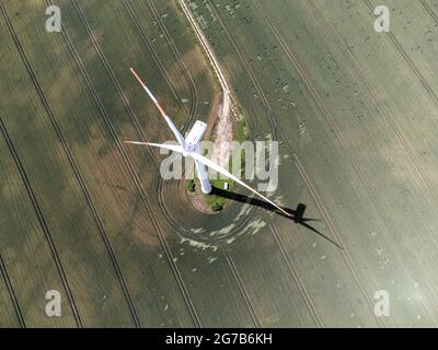 Aerial view of a wind turbine in the foreground and a large solar panel ...