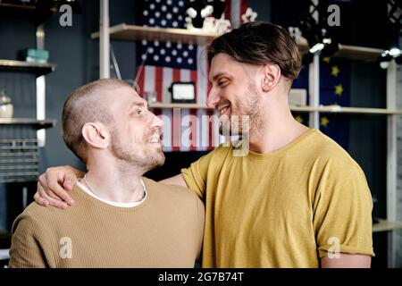 Two young affectionate gay men embracing and looking at each other Stock Photo