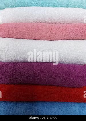 Multi-colored cotton terry towels are stacked Stock Photo