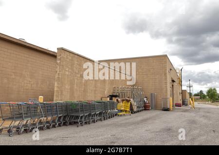 Augusta, Ga USA - 04 15 21: Rows of broken shopping carts metal racks  behind a Walmart store - Tobacco Road Stock Photo