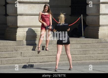 Two young women, taking photographs. Posing Stock Photo