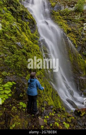 Karen Rentz at Skookum Falls, beautiful in spring runoff, along Skookum Flats Trail, Mount Baker-Snoqualmie National Forest, Washington State, USA Stock Photo