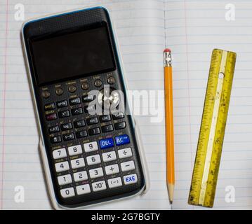 A Calculator, Pencil, and Ruler on a Notebook Stock Photo