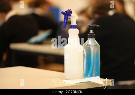 A view inside a school classroom with hand sanitiser and face mask sitting on a desk. Covid corona virus safe school or learning. Stock Photo