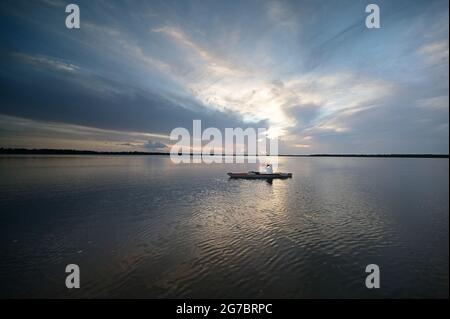 Woman kayaking on Coot Bay in Everglades National Park, Florida at sunset. under dramatic summer cloudscape. Stock Photo