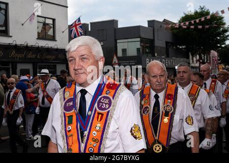 Orangemen march through the staunchly Loyalist Shankill Road during the annual July 12th parades. The annual 12th of July Orange Order parades took place this year after a hiatus due to the pandemic. Despite speculations of a potentially heated weekend due to the Brexit protocols and recent related tensions as well as certain contentions bonfire builds throughout the North, the festivities passed peacefully. The parade season marks the anniversary of the protestant King William of Orange's victory over the Catholic forces of King James at the Battle of the Boyne in 1690. (Photo by Graham Marti Stock Photo