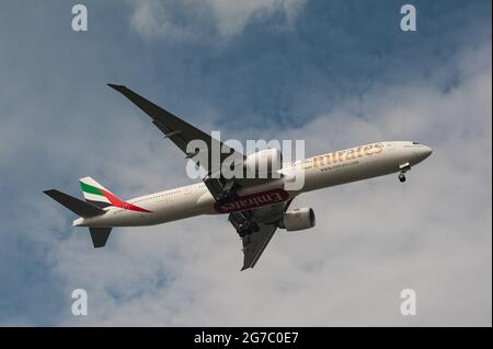08.07.2021, Singapore, Republic of Singapore, Asia - An Emirates Airline Boeing 777-300 ER passenger jet approaches Changi Airport for landing. Stock Photo