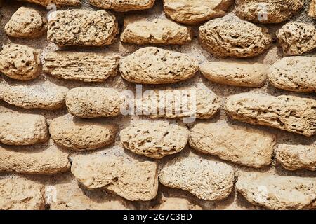 Background of the stone wall of the castle made of stones of different shapes and sizes and textures Stock Photo