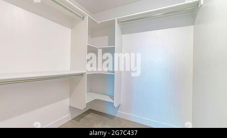 Pano Walk in closet of house with empty built in shelves and two levels ...