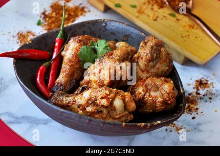 Hot and spicy chicken wings serving in black bowl with red chilli Stock Photo