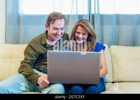 Smiling mature man and woman talking on video call with laptop Stock Photo