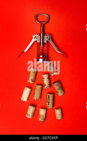 corkscrew for wine and corks on a red background. Stock Photo