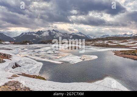 Scenic mountain lake in the Swiss Alps. Totesee, Totensee at the Grimsel Pass in Switzerland, Canton of Valais. Ice floes on the lake in summer. Stock Photo