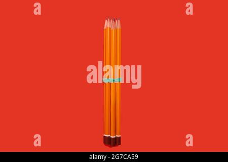 pencils lying on a red background. school accesories Stock Photo