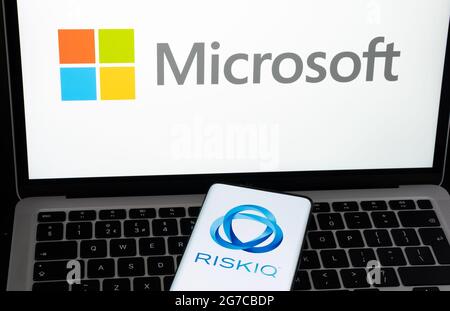 RiskIQ company logo seen on the smartphone and Microsoft logo on the blurred laptop. Concept for company buy out. Stafford, United Kigdom, July 13, 20 Stock Photo