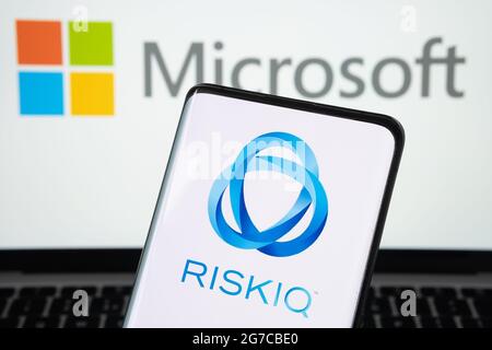 RiskIQ company logo seen on the smartphone and Microsoft logo on the blurred laptop. Concept for company buy out. Stafford, United Kigdom, July 13, 20 Stock Photo
