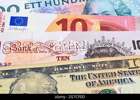 Euro, Dollar, Kroner and Sterling notes on a slate background. Stock Photo