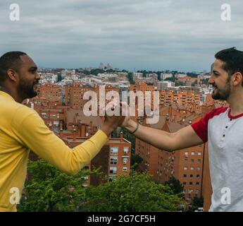 Interracial friends talking and laughing in a park Stock Photo