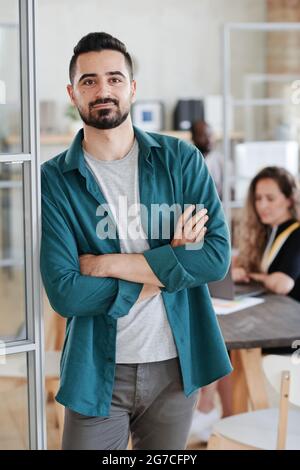 Portrait of young businessman looking at camera while working with his colleagues at office Stock Photo