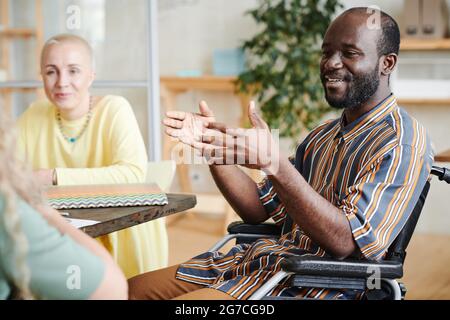 African disabled businessman talking to his colleagues during business meeting at office Stock Photo