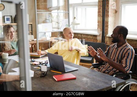 African disabled businessman discussing new strategy together with his partners during business meeting Stock Photo