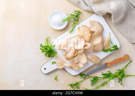 Organic oyster mushrooms with herbs and salt on cutting board Stock Photo