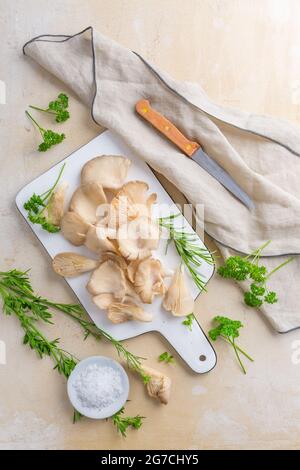 Organic oyster mushrooms with herbs and salt on cutting board Stock Photo